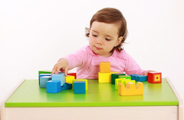 Ein Kleinkind baut einen Turm aus Bausteinen