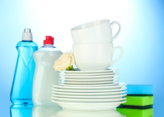 empty clean plates and cups with dishwashing liquid and sponges