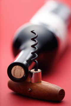 Wine Bottle And Corkscrew On Red Background