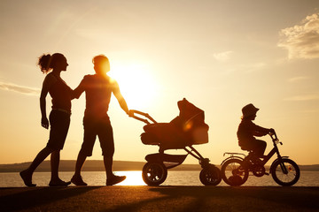 happy family walking on sunset