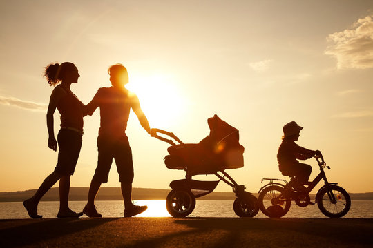 Happy Family Walking On Sunset