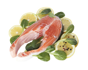 Red fish with lemon, green leaves and pepper isolated on white.