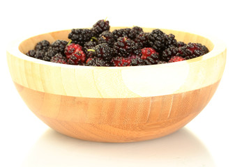 Wooden bowl with ripe mulberries isolated on white close-up