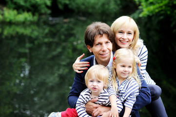 Naklejka premium Happy parents with children posing outdoors