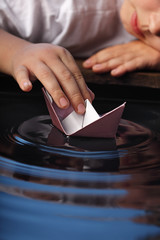 paper ship in children hand