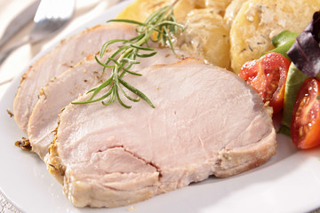 slice of roast pork and vegetables