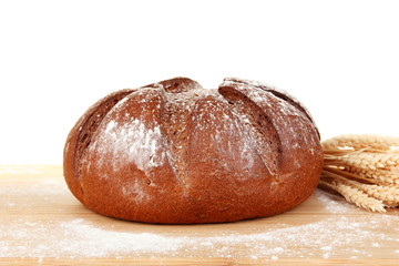 Homemade whole bread on wooden cutting board close-up