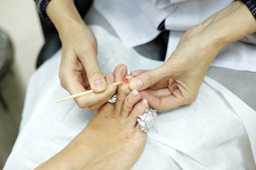 Female hands, cleaning finger nails of the woman foot