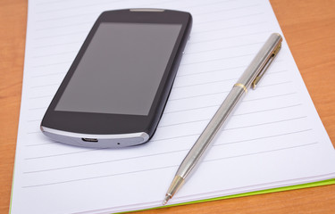 mobile phone,pen,open notebook