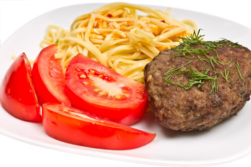 pasta with sauce, cutlet and tomato on a plate
