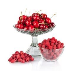 fresh raspberries and red cherries in a bowl isolated on white