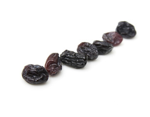 Black raisins set on white background.