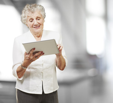 portrait of senior woman touching digital tablet, indoor