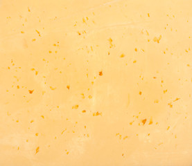 Background of fresh yellow Swiss cheese with holes