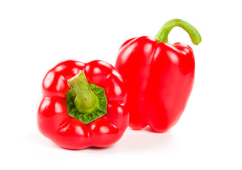 two fresh red peppers on white