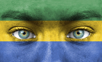 Human face painted with flag of Gabon