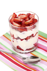 Glass of ripe strawberries with cream isolated on white