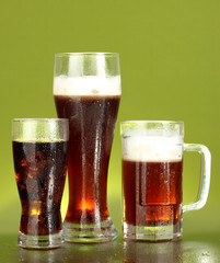 refreshments - beer, cola and kvass on green background