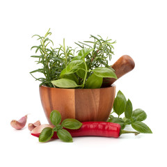 fresh flavoring herbs and spices in wooden mortar