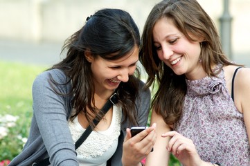 Two girls While They Speak with a cellular