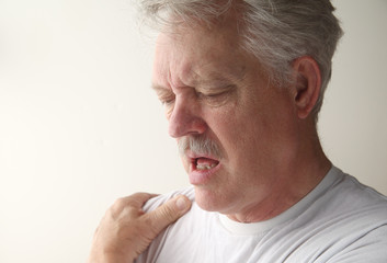 a man suffers from pain in his shoulder