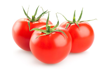 three fresh tomatoes with green leaves isolated on white backgro