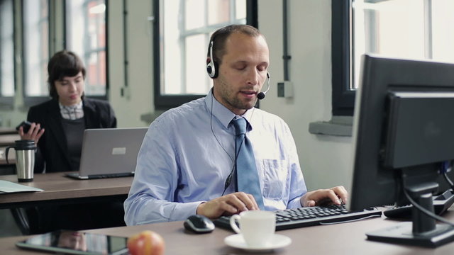 Friendly happy male helpdesk consultant in the office