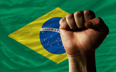Hard fist in front of brazil flag symbolizing power - obrazy, fototapety, plakaty