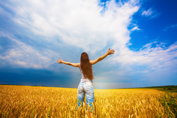 Girl with outstretched arms is enjoys summer day