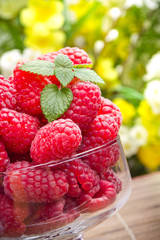 Sweet fresh raspberry fruits in glass goblet