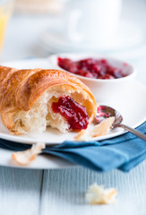 Croissant with sour cherry jam on a plate
