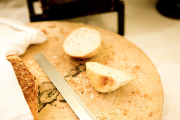 Wooden cutting board with sliced white bread and knife on wooden