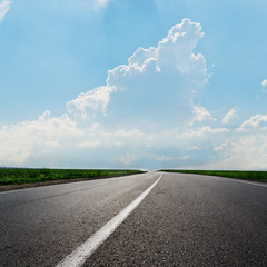 asphalt road to horizon under cloudy sky