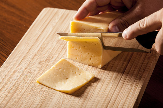 Man Cutting Piece Of Cheese