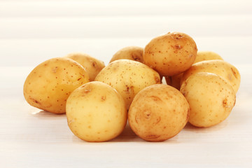 young potatoes on white wooden table close-up