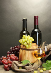 barrel, bottles and glasses of wine and ripe grapes