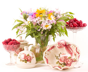 Obraz na płótnie Canvas Vintage herbaty w eleganckiej zastawy stołowej, malin wiśni i kwiatów