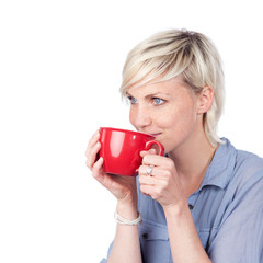 blonde frau trinkt aus roter tasse