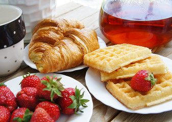 Tasty breakfast - tea, croissants, wafers with cream
