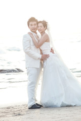 groom and bride standing at sea beach