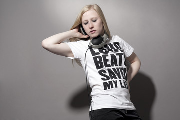 Junge Frau mit Kopfhörern und bedrucktem T-Shirt