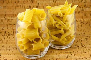 Two varieties of pasta inside two transparent glasses