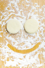 Dough for donuts on wooden table