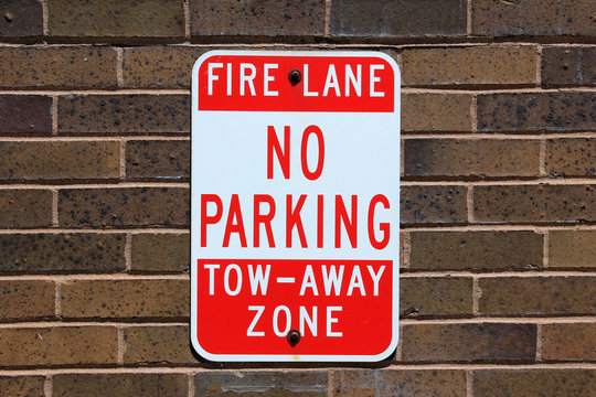 No parking sign posted on a brick wall