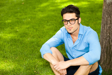 Naklejka na ściany i meble handsome man standing on the grass