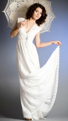 Young woman in retro bridal dress with umbrella on background.