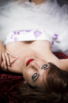 Red Hair. Fashion Girl Portrait. young woman lying on sofa, shal