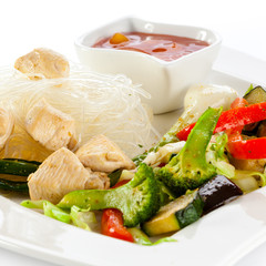 Roasted meat, rice noodles and vegetables on white background