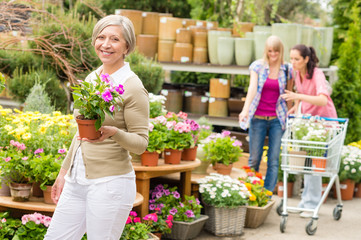 Garden center senior lady hold potted flower