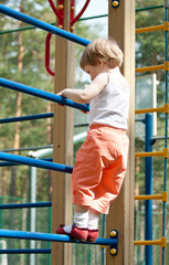 Obraz premium Active little child climbing on a high ladder
